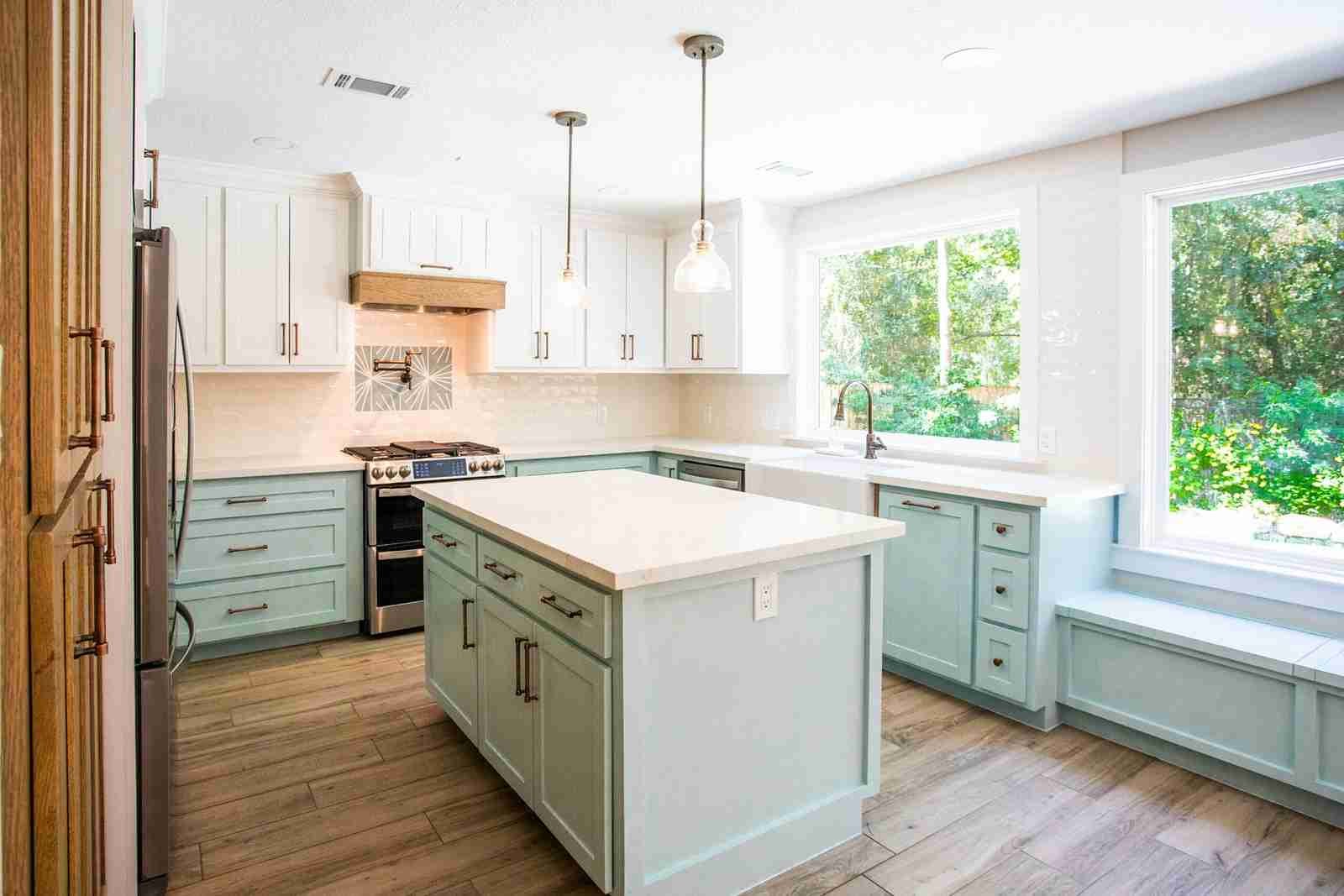 Modern kitchen remodel in The Woodlands with warm cabinetry, quartz countertops and large island