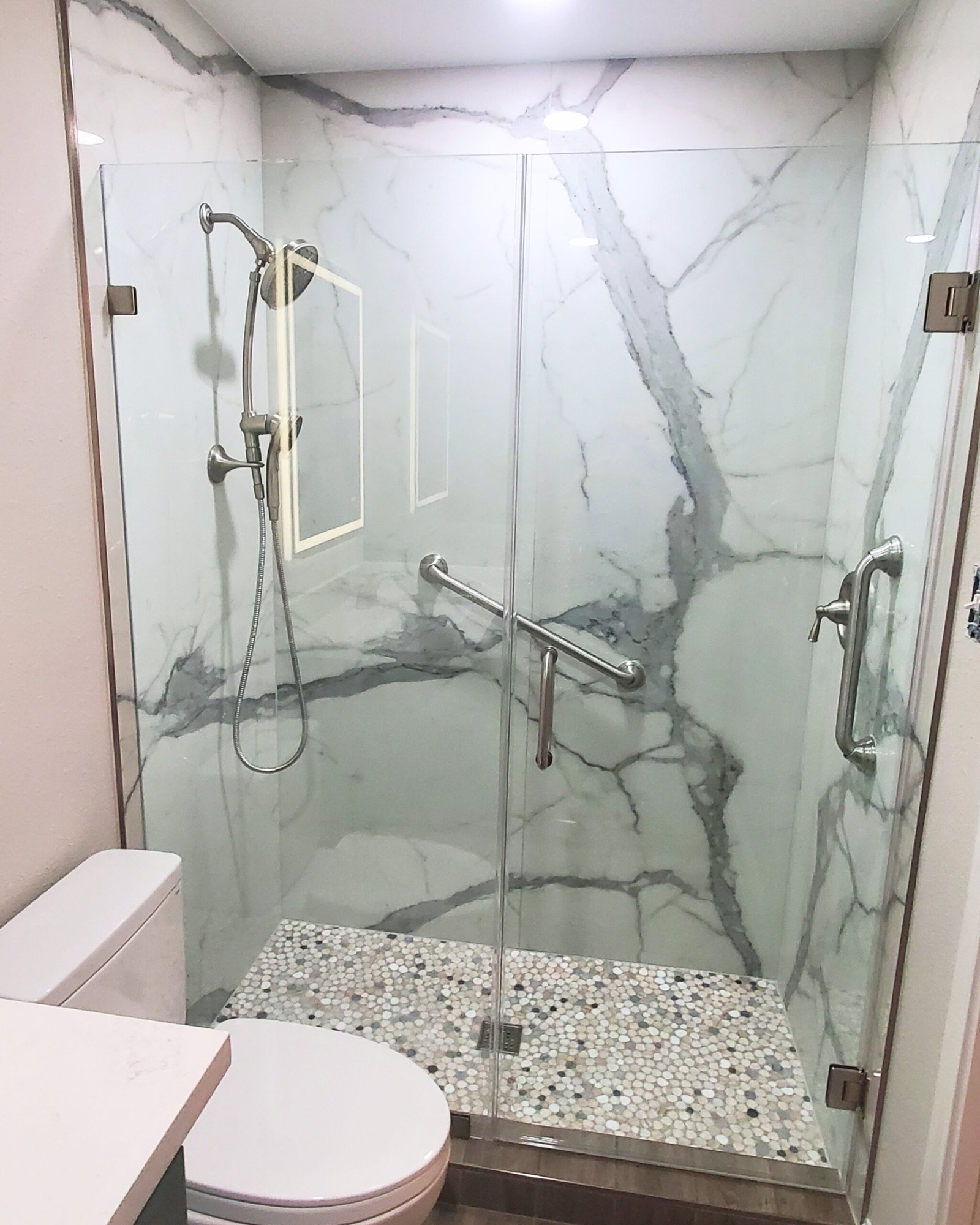 Modern handicap accessible bathroom renovation featuring a built-in shower bench and zero-entry floor.